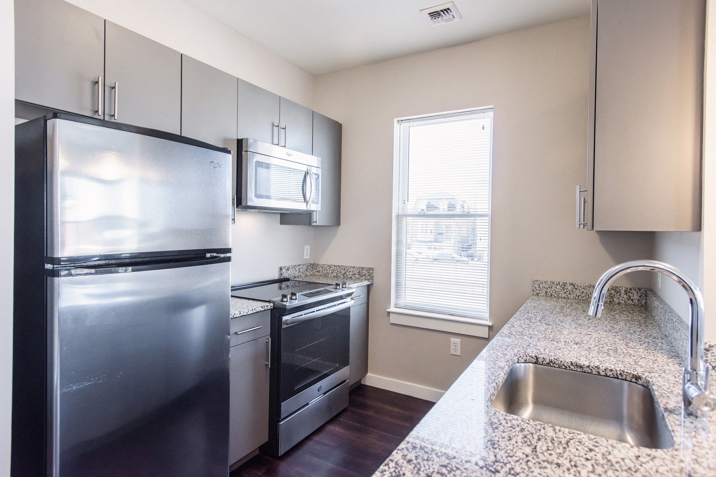 an empty kitchen with stainless steel appliances and granite counter tops